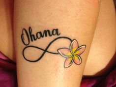 a woman with a tattoo on her leg that says ohana and has a flower in the center