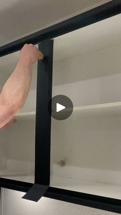 a man is fixing the sliding glass door on a refrigerator in an empty room with white walls