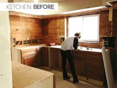 a man standing in a kitchen next to a window