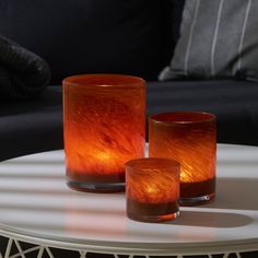 three candles sitting on top of a white table