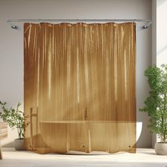 a bathroom with a shower curtain and potted plants on the floor in front of it