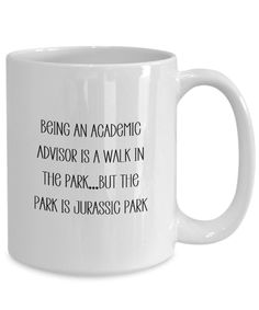 a white coffee mug with the words being an academic advisor is a walk in the park but the park is jurassic park