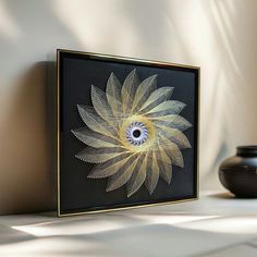 a black vase sitting next to a yellow and white painting on the side of a wall