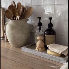 a bathroom counter with wooden spoons and soap dispensers