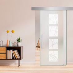 an empty room with a book shelf and sliding glass door in the center, next to a plant