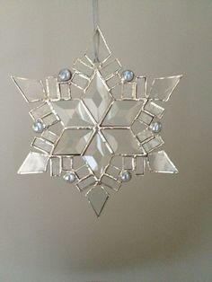 a glass snowflake hanging from a ceiling