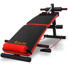 a red and black exercise bench with two handles on each side, sitting in front of a white background