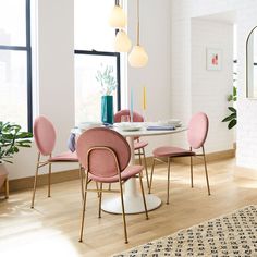 a dining room table with pink chairs around it