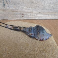 a piece of glass sitting on top of a wooden table next to a string attached to it