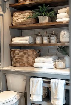 a white toilet sitting next to a shelf filled with towels