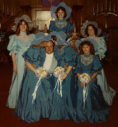 a group of people in blue dresses posing for a photo