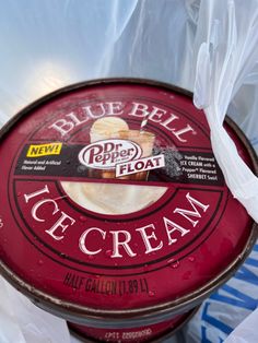 an ice cream container sitting on top of a plastic bag filled with blue bell ice cream