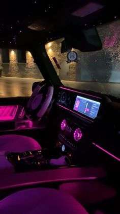 the interior of a car with purple lighting and dashboard lights, including an entertainment system