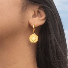 Meet the Araw Drop Earrings, a standout piece from our esteemed Araw Collection. These earrings seamlessly blend our timeless 17mm hoops (Kim Everyday Hoops) with a unique design inspired by historical coins, featuring a modernized rendition of the iconic Philippine Sun. The sun, presented in a glossy mirror finish against a matte sandblasted background and surrounded by golden beads reminiscent of vintage coin ornamentation, celebrates heritage with a contemporary flair that’s distinctly ours. Symbolic Yellow Gold Round Earrings, Yellow Gold Medallion Brass Earrings, Yellow Gold Coin Jewelry, Symbolic Round Earrings, Elegant Yellow Gold Earrings With Coin Pendant, Coin Pendant Medallion Earrings For Gift, Coin Shaped Earrings As A Gift, Brass Medallion Earrings With Coin Pendant, Brass Coin Pendant Medallion Earrings