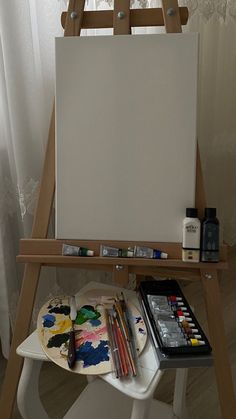 an easel with paint and other art supplies