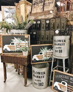 several metal buckets with flowers in them on display