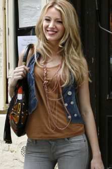 a beautiful young blond woman holding a purse