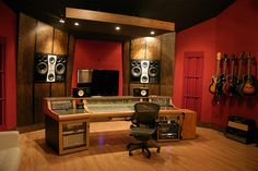 a recording studio with red walls and wooden floors