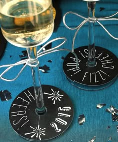 two wine glasses sitting next to each other on top of a blue cloth covered table