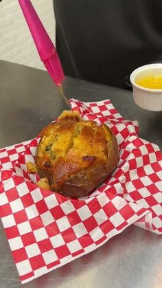 a muffin sitting on top of a red and white checkered napkin