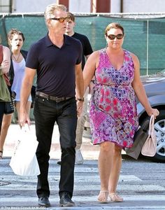 the man and woman are walking down the street with their shopping bags in each hand