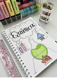 an open notebook with markers and pens on it next to some other items that include crayons