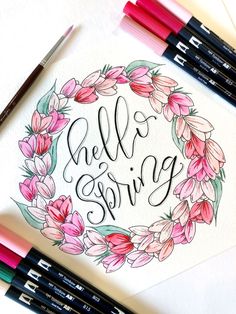 a drawing with markers and pens on top of it that says hello spring in the center