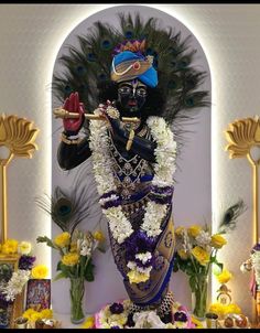 the statue is decorated with flowers and feathers