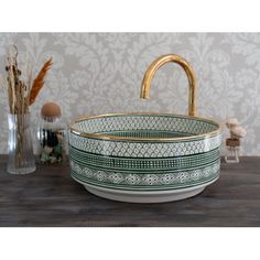 a green and white bowl sink sitting on top of a wooden table