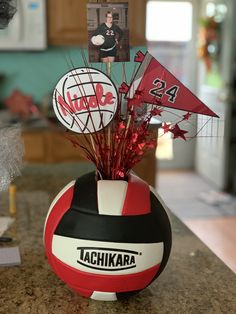 a red, white and black ball with pictures on it sitting on top of a counter