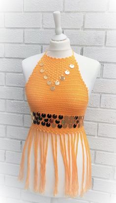 Crochet a festival halter crop top that oozes Coachella appeal. It's embellished with fringing and sequins and fastens at the neck and back with ties. Yarn Requirements: 2 balls of DMC Petra 3 Yellow (5742) are needed for all sizes including fringe Tension; 18 sts and 10 rows to measure 10x10cm (4x4in) over treble st using a 3.50mm hook or size required to obtain tension. MEASUREMENTS SIZE XS S M L Width at Top 16 16 16 16 cm 6¼ 6¼ 6¼ 6¼ in Width Front 37 39 41 47 cm (widest point) 14½ 15¼ 16 18 Crochet Halter Top Pattern Free, Halter Top Crochet, Boho Halter Top, Crochet Halter Top Pattern, Easy Beginner Crochet Patterns, Halter Top Pattern, Sweater Tutorial, Summer Top Pattern, Top Crochet Pattern