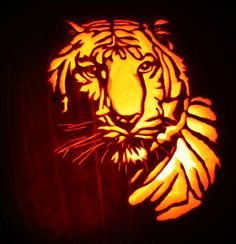 a carved pumpkin with an image of a tiger on it's face in the dark