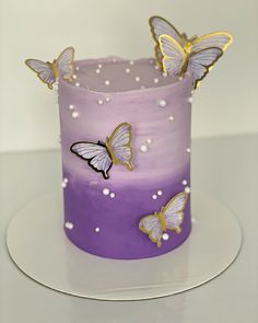 a purple and white cake with butterflies on it