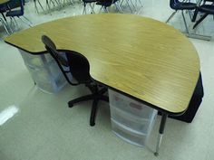 an empty classroom with desks and chairs in the middle, one has a plastic container on it