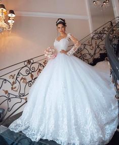 a woman in a wedding dress standing on the stairs