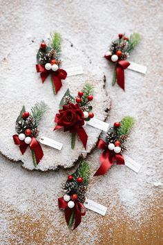 four pieces of cake are decorated with red bows and pineconis, while snow is scattered around them