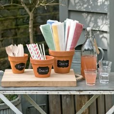 a table topped with pots filled with different types of utensils and napkins