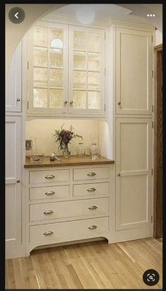 a kitchen with white cabinets and wooden floors