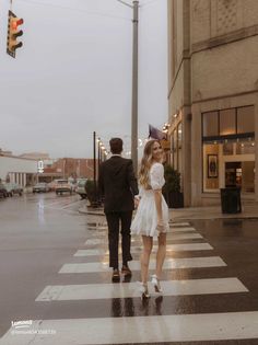 a man and woman walking across a cross walk