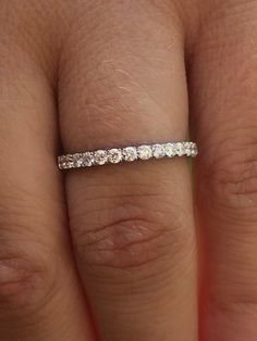 a woman's hand with a wedding band on it, and the ring has five stones