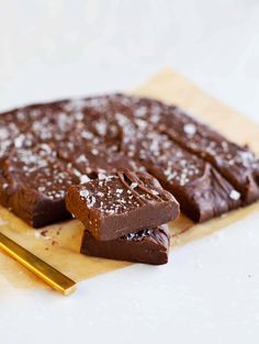 two pieces of chocolate cake sitting on top of a cutting board