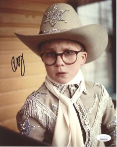 a man in a cowboy hat and glasses wearing a white shirt with silver sequins