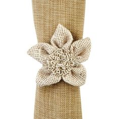 a white flower is on top of a burlocked cloth napkin holder,