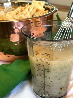 a measuring cup filled with food next to a metal mixing bowl