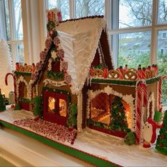 a large gingerbread house decorated with candy canes and icing on the windowsill