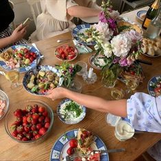 people sitting at a table with plates of food