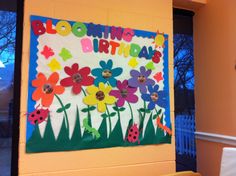 a bulletin board with flowers and ladybugs on it in front of a window