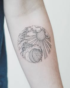 a person with a tattoo on their arm that has an image of a wave and sun