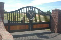 a gate with a sign that says y on it and some brick pillars in the background