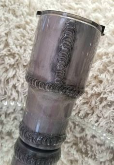 a silver vase sitting on top of a white rug